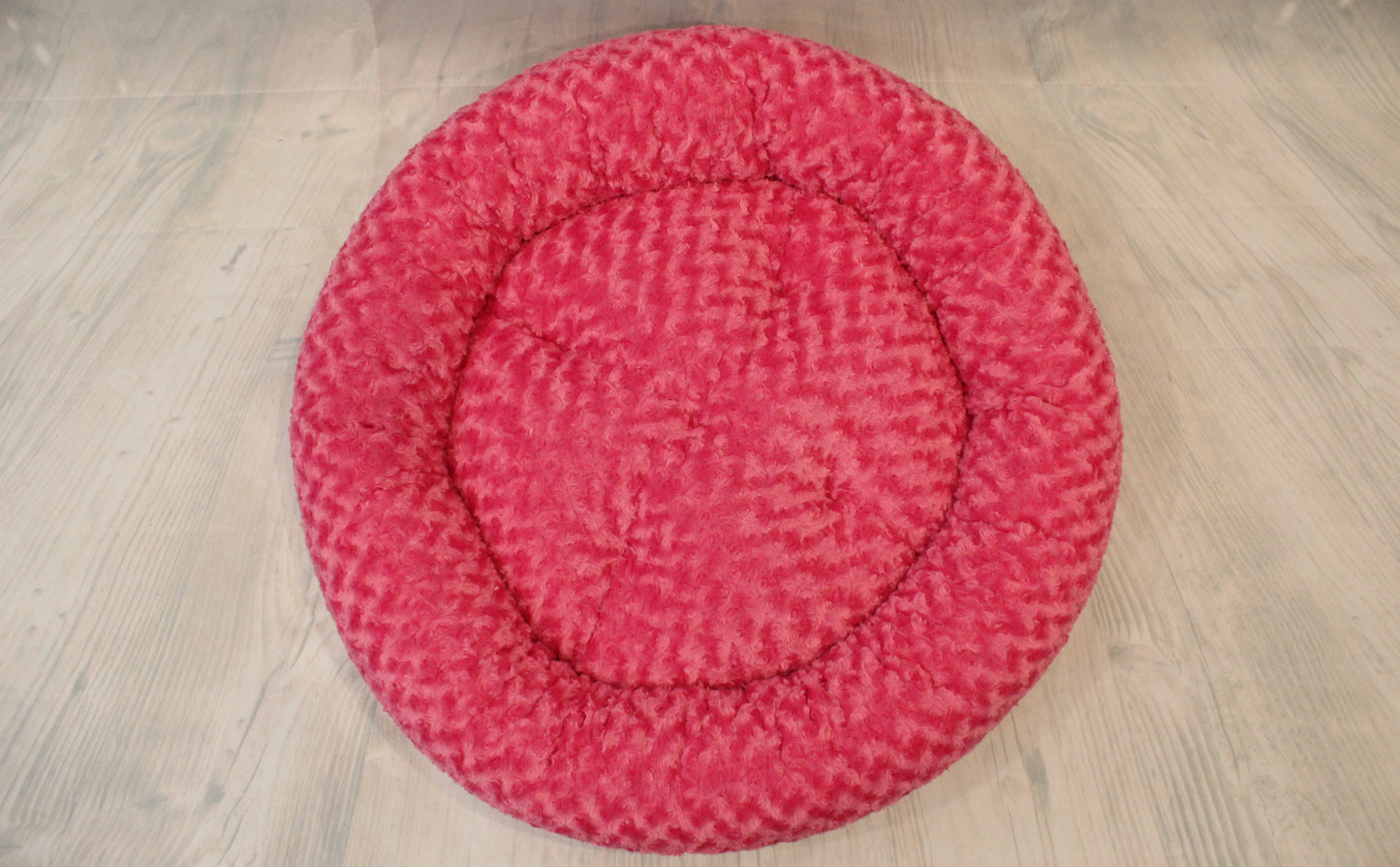 Pink triangle print round nest dog bed top view